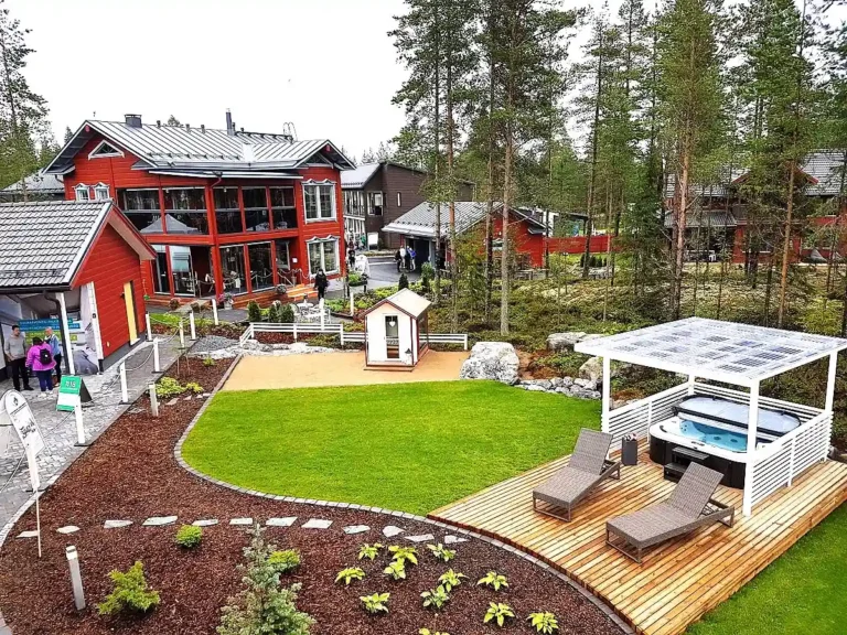 KAASAEGSE PUHKEALA, MULLIVANNI JA LÄBIMÕELDUD HALJASTUSEGA ELAMUKOMPLEKSI ÕUEALA SEINÄJOKI ELAMUMESSIL. Punased puitvoodriga eramajad, terrass lamamistoolidega ja mullivann hoovis – Soome elamumess 2016 Seinäjoki linnas.