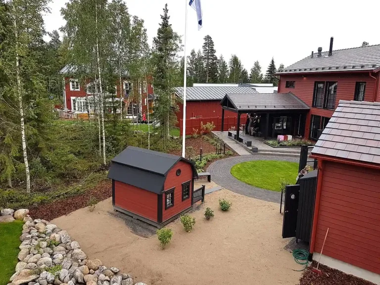 TRADITSIOONILISES STIILIS ELAMUKOMPLEKS KOOS LÄBIMÕELDUD HALJASTUSE JA KÕRVALHOONETEGA SEINÄJOKI ELAMUMESSIL. Punased puitvoodriga eramajad ja tumedad kaldkatused – Soome elamumess 2016 Seinäjoki linnas.