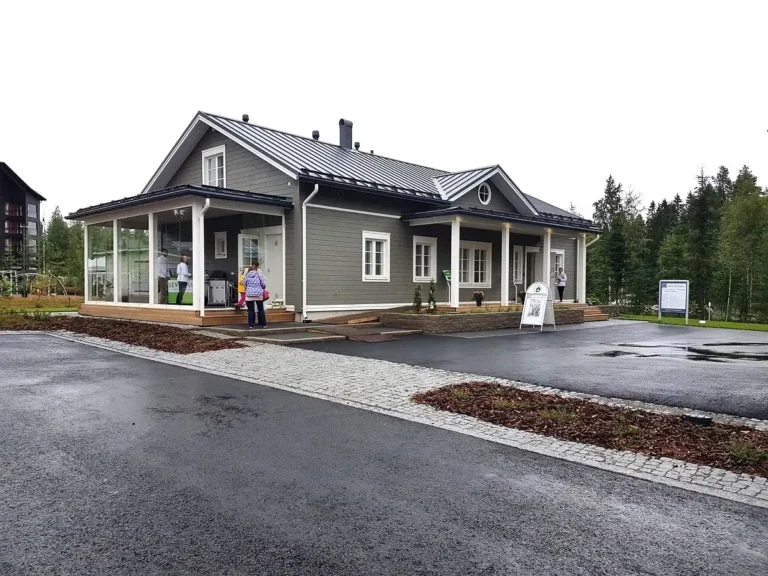 KLAASITUD VERANDA JA KEERUKA VIILKATUSEGA NÄIDISERAMU SEINÄJOKI ELAMUMESSI VÄLIALAL. Klassikaline hall puitvoodriga eramu ja tume viilkatus – Soome elamumess 2016 Seinäjoki linnas.
